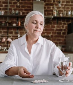 Elderly person holding a glass of water